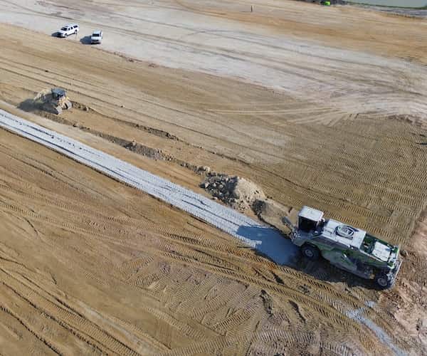 dirt field with trucks moving across it